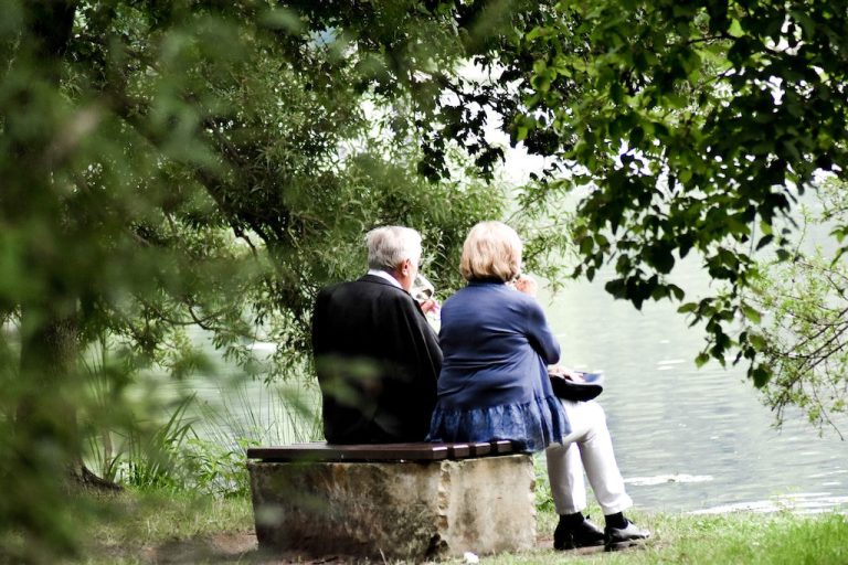Para seniorów na ławce przy jeziorze
